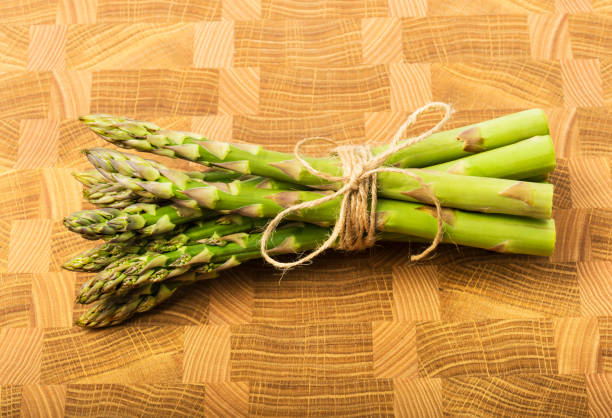istock Bunch of fresh asparagus on wooden table 1386682090