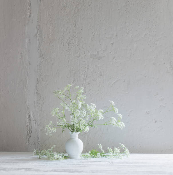 istock white wild flowers in vase on white background 1386682482