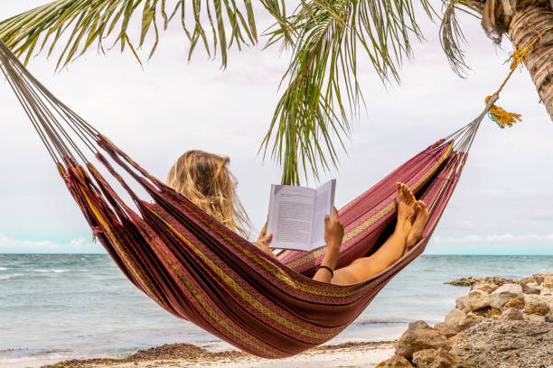 istock Happy woman relaxing in hammock 1386683685