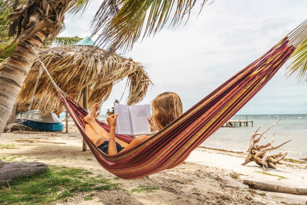 istock Happy woman relaxing in hammock 1386684108