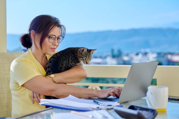 istock Home workplace female freelancer working remotely with pet cat in her arms 1386685173
