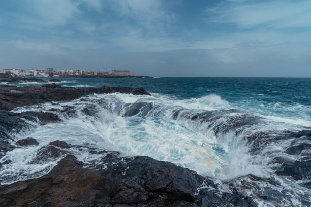 istock Waves beating in a a hole formed in the rocks . Impressive rock formation in Telde. Gran Canaria. Canary islands 1386685231