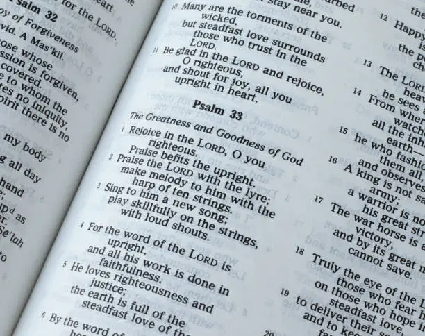Psalm 33, greatness and goodness of God Jesus Christ, Old Testament Scripture. An open Holy Bible Book. A closeup. The Christian biblical concept of love, faith, and hope in the LORD.
