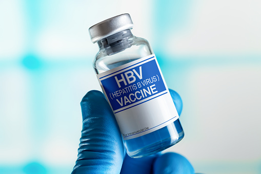 Médico con vial de la vacuna de dosis para el VHB contra la enfermedad por el virus de la hepatitis B. Concepto de vacunación y atención sanitaria photo