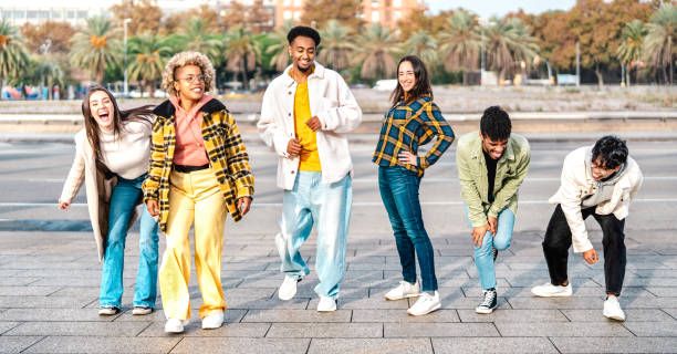 istock Multiracial students walking at Barceloneta beach broadwalk acting funny move - Young guys and girls having fun together on party mood - Travel life style concept on bright filter - Focus on mid frame 1386690794