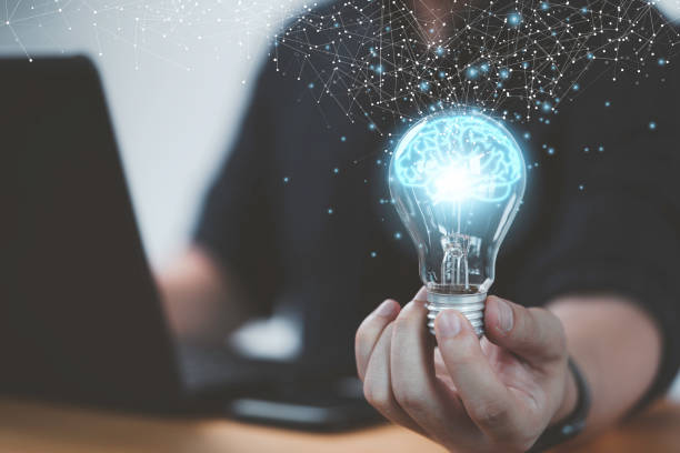 istock Businessman hand holding lightbulb with glowing virtual brain and  connection line to creative smart thinking for inspiration and innovation with network concept. 1386693107