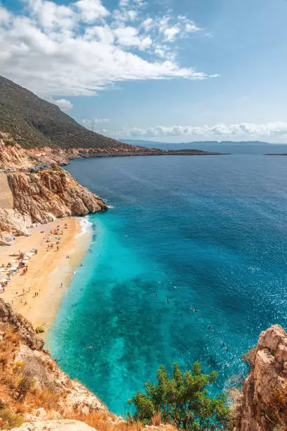 Kaputas beach with blue water on the coast of Antalya region in Turkey with sun umbrellas on the beach. Vertical orientation. Travel destination