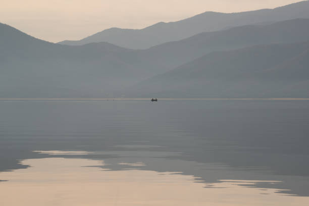 istock Fishing boat lake with reflection. Mountain range. Soft colors. 1386694445