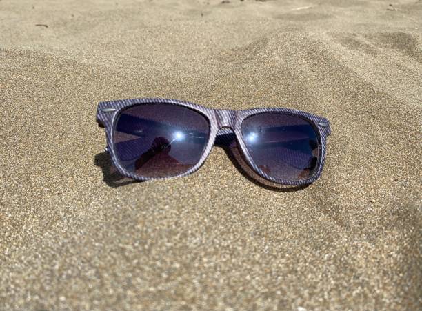 istock Sunglasses lying in the sand on a sunny day 1386694916