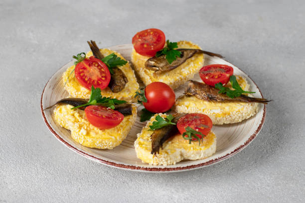 sandwiches with sprats, cheese, egg and cherry tomatoes in the form of hearts on gray background, idea for valentine's day - cherry valentine stok fotoğraflar ve resimler