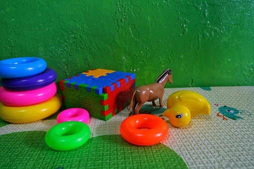 Several kid toys like Rings, cubes, ducks and horse toys made from plastic