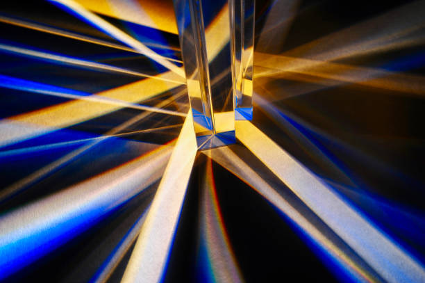 Triangular glass prisms dispersion of light Closeup of group of reflective clear triangular prisms dispersing and spreading beam of light in to spectrum and criss cross line on white paper background. Refracted blue light with artistic pattern refraction photos stock pictures, royalty-free photos & images