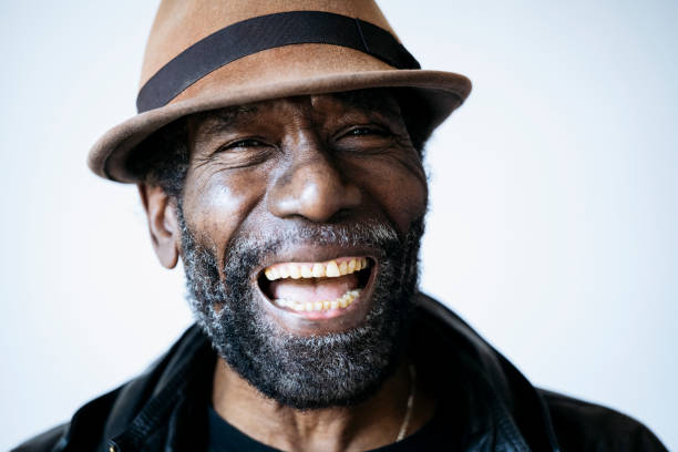 istock Stylish senior man in porkpie hat laughing 1386700997