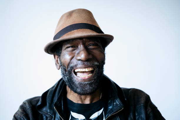 Studio shot of laughing 69 year old Caribbean man