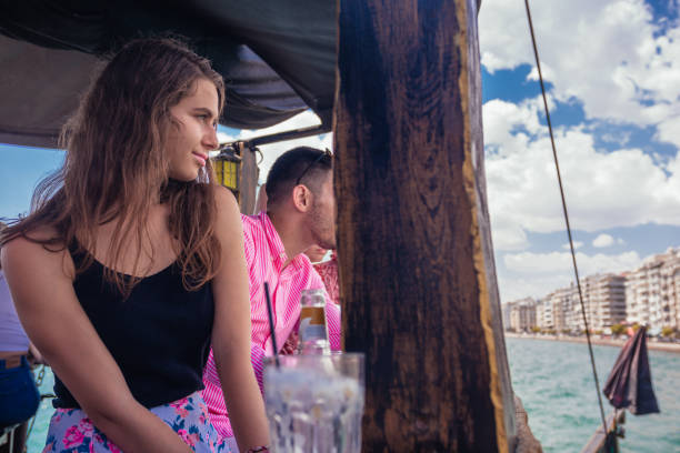 фото профиля привлекательной девушки, сидящей на крыльце лодки и смотрящей в прекрасное море - child looking messy urban scene стоковые фото и изображения