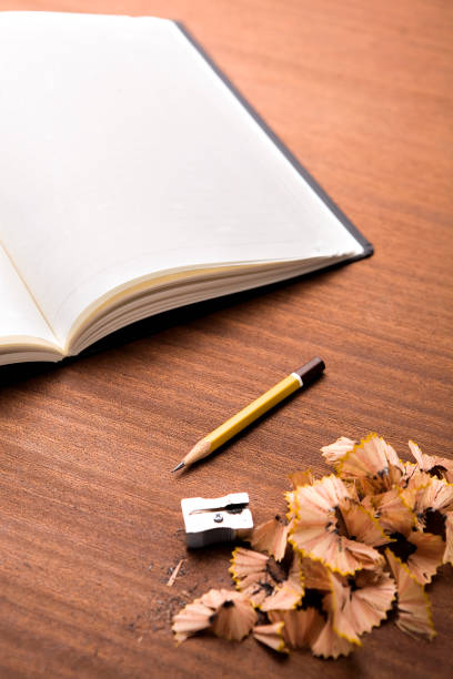 Notepad, pink pencil, paper basket with crumpled paper sheets and on a corrugated pink surface.