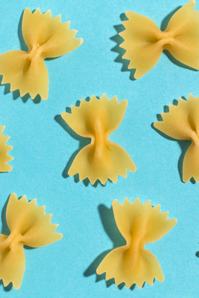 istock Uncooked italian farfalle pasta on a blue background. 1386702648