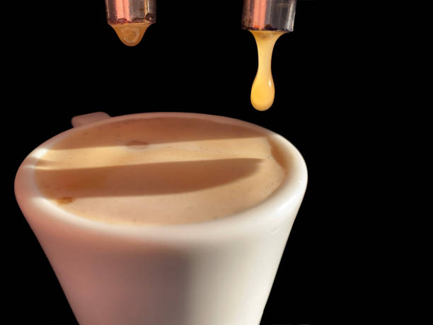 istock Espresso machine making coffee, golden espresso flowing closeup view 1386702915