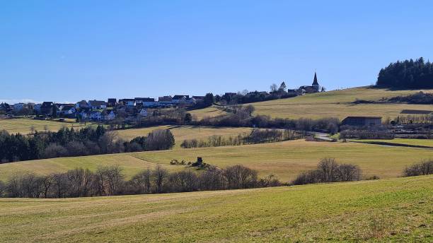 istock Idyllic landscape with village and fields in the Eifel mountains, Germany 1386703655