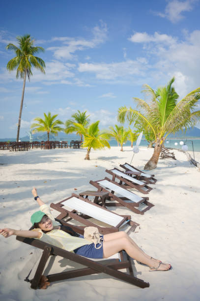Asian enjoy beach life staycation work from anywhere happy with tropical beach blue sky travel and work in krabi thailand