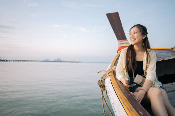 istock Asian smile with happy backpacker enjoy sightseeing enjoying looking scenics view sunset at tropical beach 1386708630