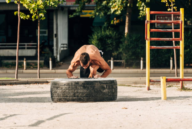 istock Man push a big tire. Street workout 1386708760
