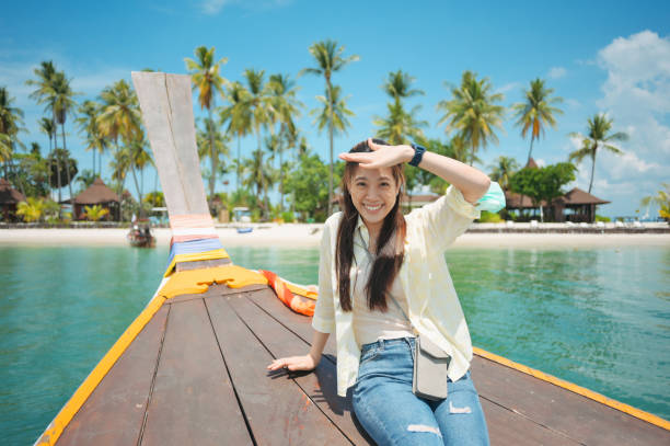 istock Asian smile with happy backpacker enjoy sightseeing enjoying looking scenics view sunset at tropical beach 1386708787