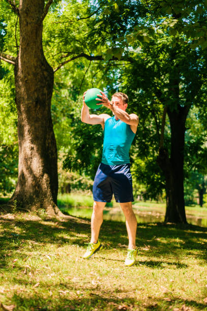 istock Active and muscular man keeping fit by exercising using a medicine ball 1386710032