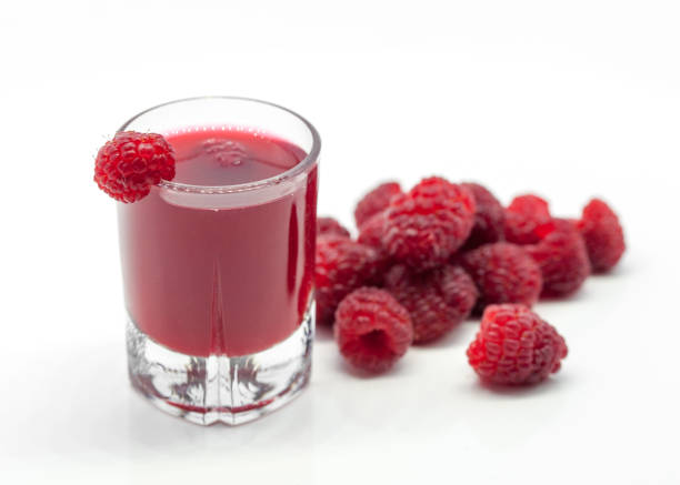 verre avec boisson alcoolisée à la framboise et framboises sur fond blanc - vinegar bottle raspberry fruit photos et images de collection