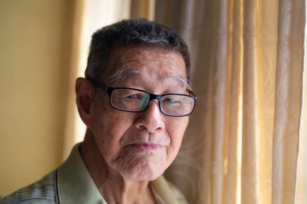Portrait of an Asian senior man standing and looking at camera.