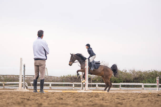 젊은 여자는 그녀의 라이더 강사와 장애물을 통해 점프 배운다 - horse show jumping jumping performance 뉴스 사진 이미지