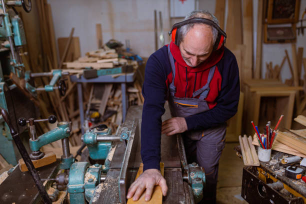 istock While wearing ear protectors, male carpenter cutting the timber plank 1386711952