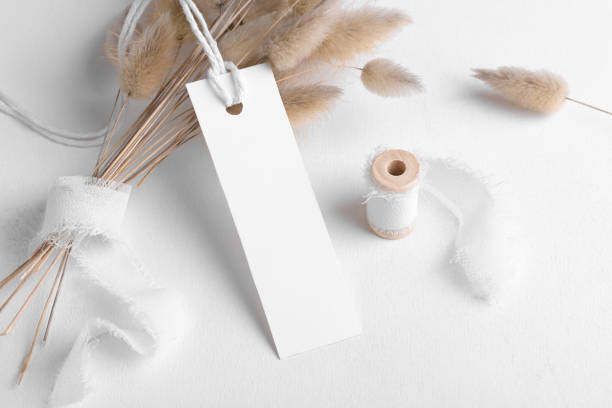 Rectangle white tag mockup on a white background with cotton string and boho decoration, dry plants, element for packing