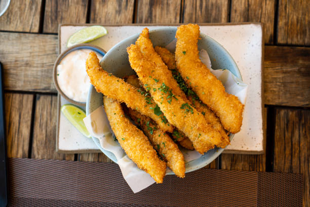 istock Fresh fried Brazilian tilapia fish strips with lime and tartar sauce known as isca de peixe. Traditional Brazilian appetizer. Selective focus 1386712906