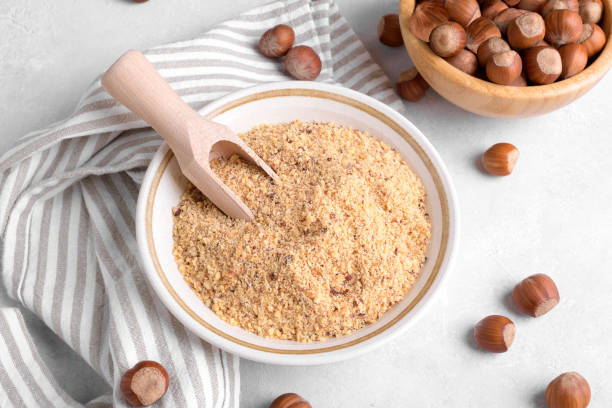 istock Raw Organic Ground Hazelnut Flour in a Bowl with whole nuts on grey stone background. Alternative nut flour 1386714045