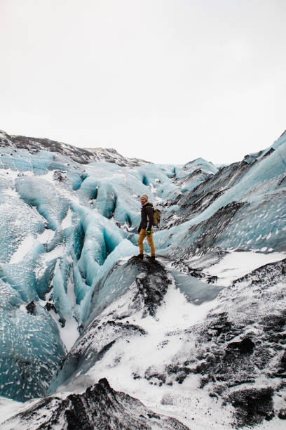 The man standing on glacier in Iceland in winter during his trip