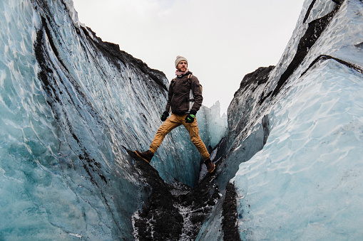 The man standing in the ice canyon in the glacier Iceland in winter