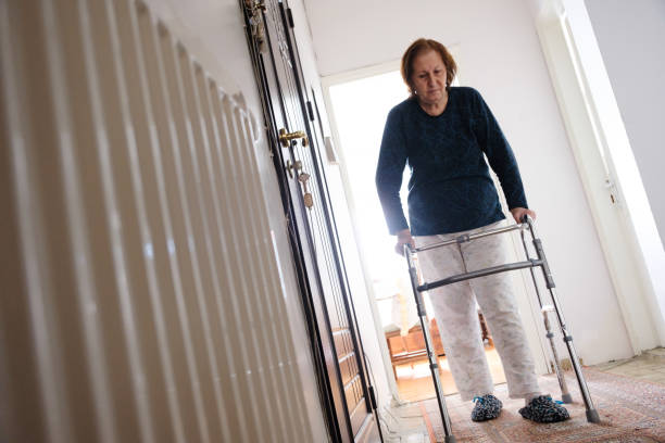 istock Senior woman first walk after surgery with mobility walker support 1386716154