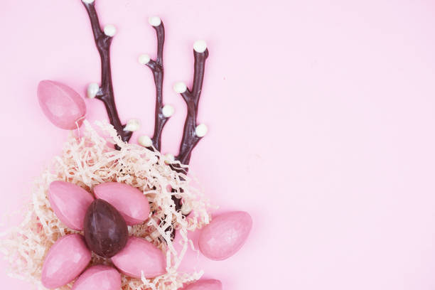 istock Beautiful Easter composition with chocolate eggs, pussy willow and a hare on a colored background, space for text. 1386716847