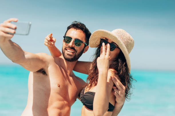 istock couple take a selfie on the beach in summer 1386720563