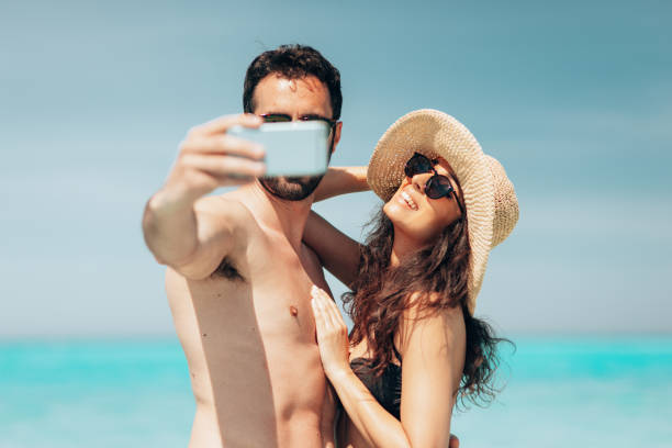 istock couple take a selfie on the beach in summer 1386720789