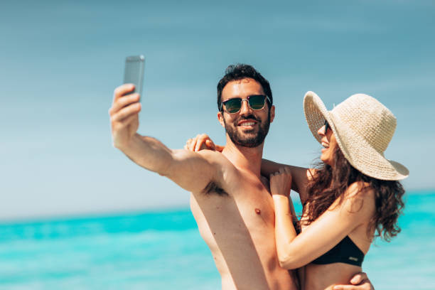 istock couple take a selfie on the beach in summer 1386720848