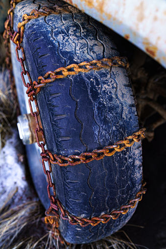 Tire with Rusty Chains - Detail of vehicle wheel rubber tire with rusty chains installed.