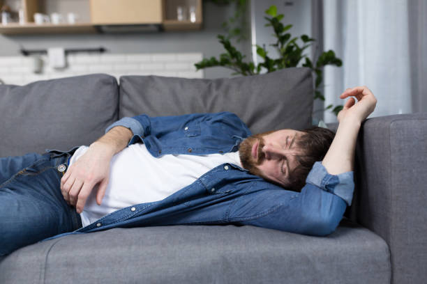 istock A man at home tired after work sleeps on the couch 1386725652