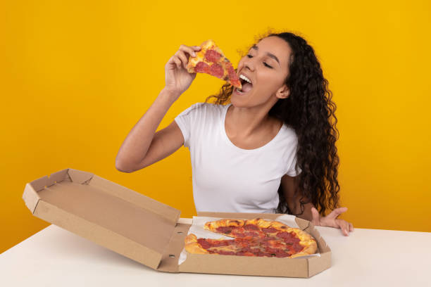 istock Happy Latin Lady Biting Pizza At Studio 1386727112