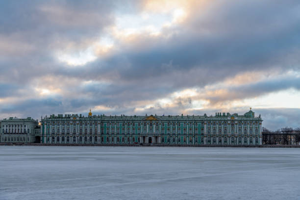 Russia, Saint Petersburg - February 26, 2022: Winter Palace of the State Hermitage Museum in Saint Petersburg city in the early winter morning. No people. Neva river covered with ice.