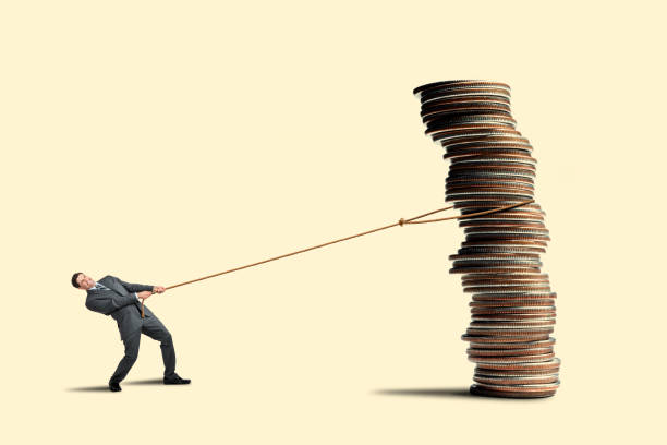 Businessman Pulls in Stack Of Coins With A Rope stock photo