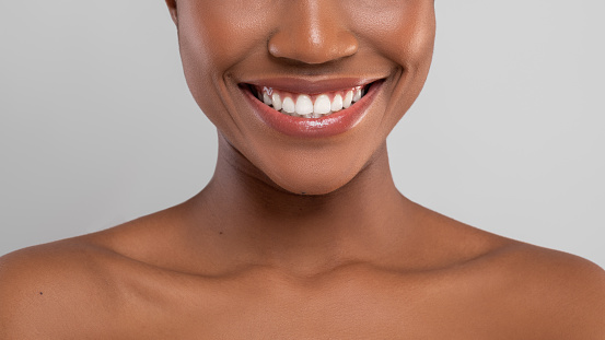 Dental Care. Closeup Portrait Of Smiling African American Female With Perfect Teeth, Cropped Image Of Young Black Woman With Bare Shoulders And Beautiful Smile Standing Over Grey Background