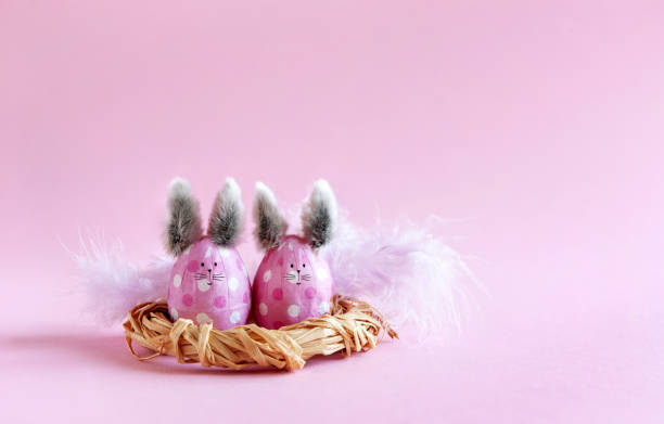 istock Pink Easter eggs in the form of bunnies on a pink background 1386730911
