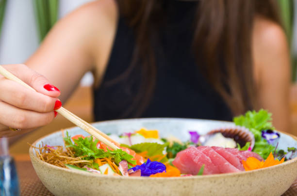 istock Woman eating delicious sushi 1386732305
